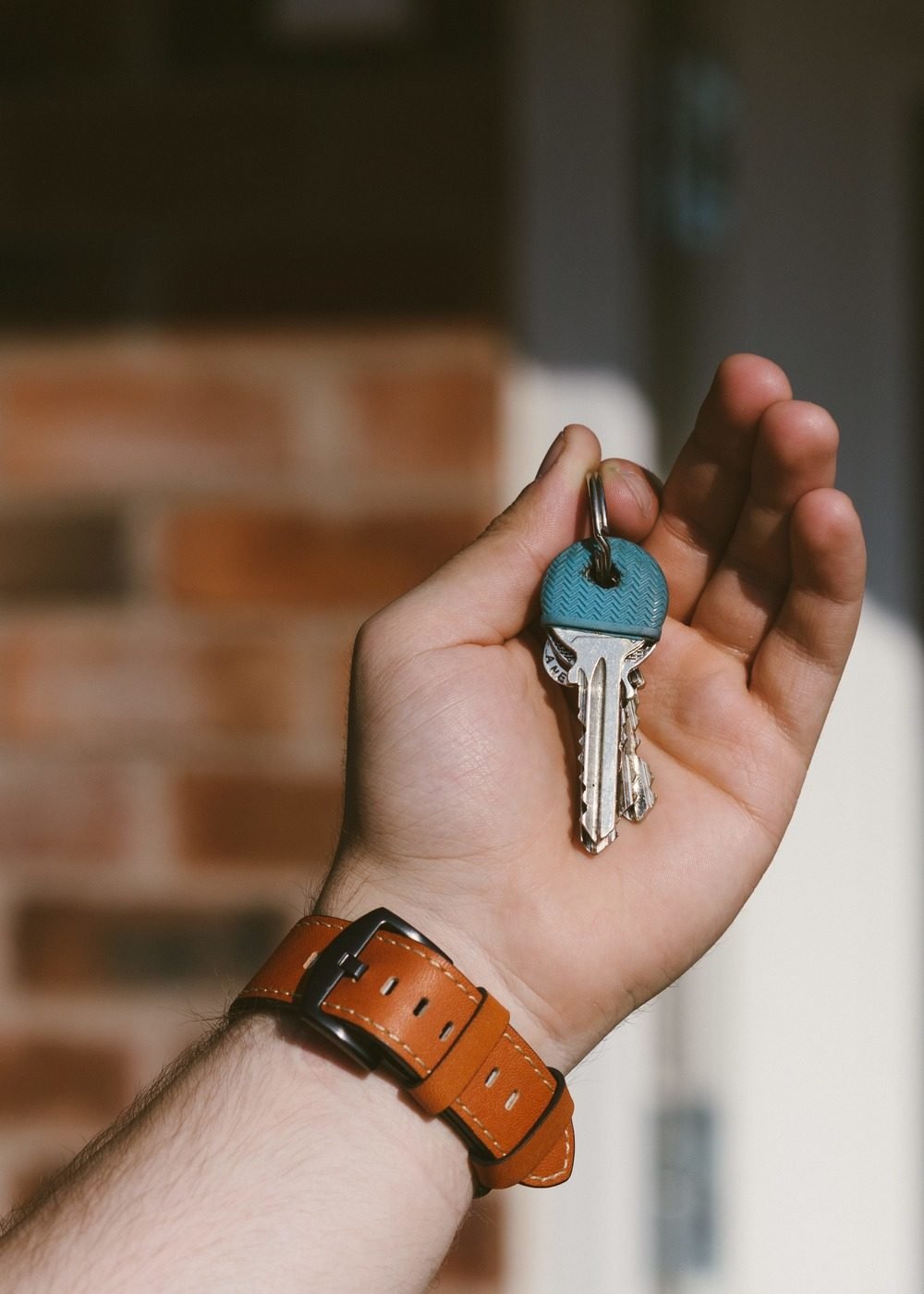 Mão aberta segurando a chave de um apartamento novo